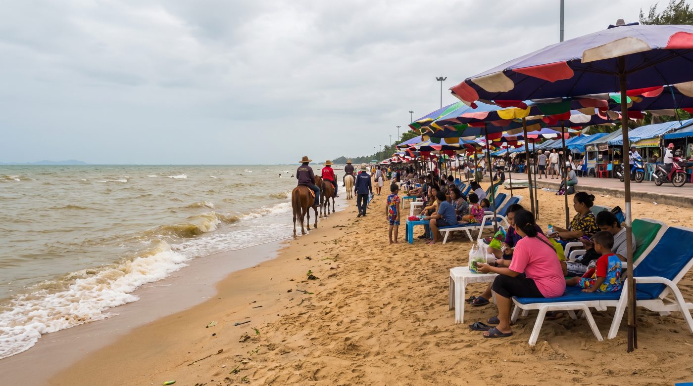 Bang Saen beach near Bangkok on a busy weekend with beach umbrellas and local visitors
