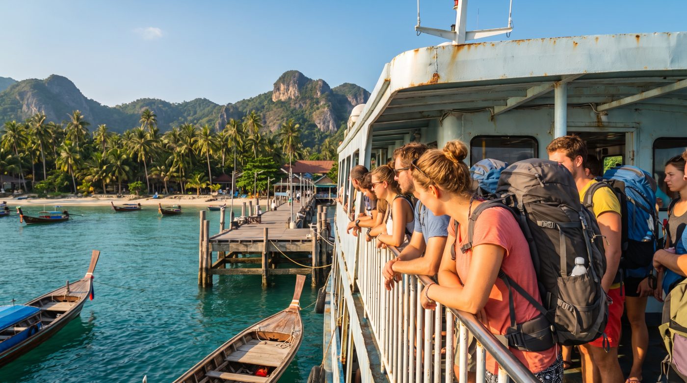 Ferry arriving at a pier on Koh Phangan with backpackers disembarking