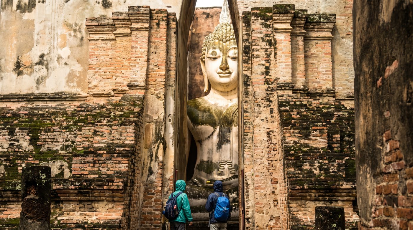 The giant seated Buddha at Wat Si Chum visible through the narrow gap in the mondop walls, Sukhothai